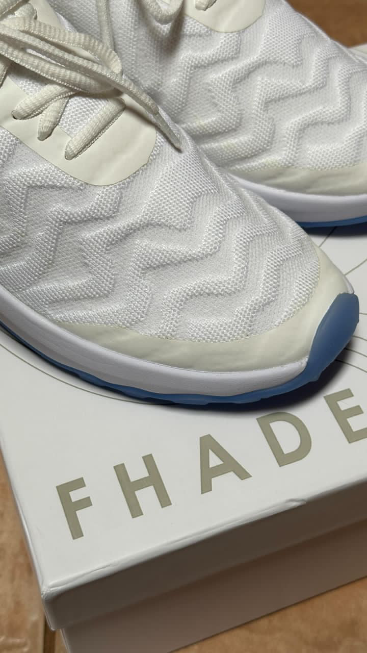 A pair of FHADE hybrid golf shoes sitting on top of a shoe box